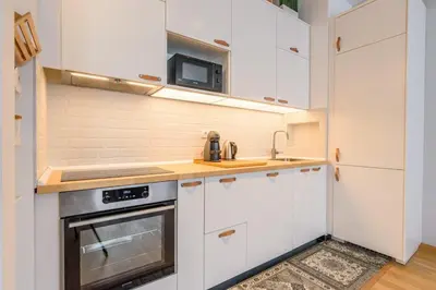a kitchen with white cabinets and a sink and a stove at Brand new flat near Tesla museum in Belgrade