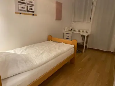 a small bedroom with a bed and a desk at Brand new flat near Tesla museum in Belgrade