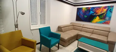 a living room with a couch and a painting on the wall at Old Café Spa Apartment - Unique space in Belgrade
