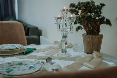 a table with a white table cloth and a christmas tree on it at Apartman David in Ruma