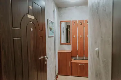 a bathroom with wooden cabinets and a sink and a mirror at Apartman David in Ruma