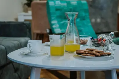 a table with a plate of cookies and a bottle of orange juice at Apartman David in Ruma