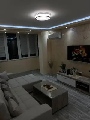 a living room with a couch and a tv at Apartman Trg Lux in Arandjelovac