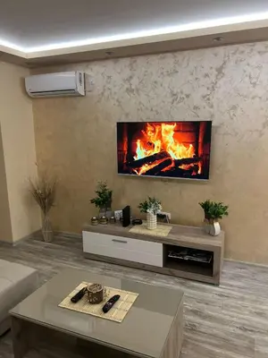 a living room with a fireplace in the wall at Apartman Trg Lux in Arandjelovac