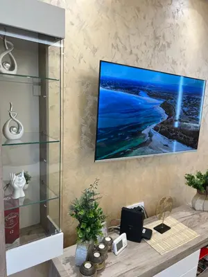 a room with a desk with a tv on a wall at Apartman Trg Lux in Arandjelovac