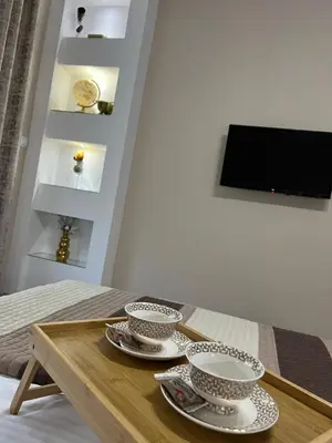 a wooden table with three bowls and plates on it at Apartman Trg Lux in Arandjelovac