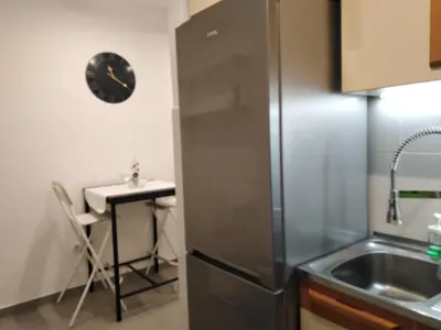 a kitchen with a stainless steel refrigerator and a table at N&AA apartman in Belgrade