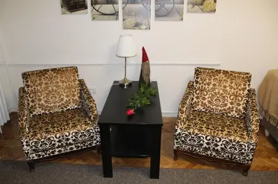 a living room with two chairs and a table with a lamp at N&AA apartman in Belgrade