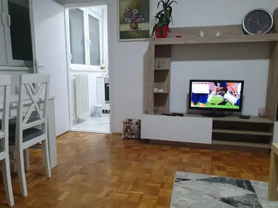 a living room with a flat screen tv on a table at AS Apartment in Tošin Bunar