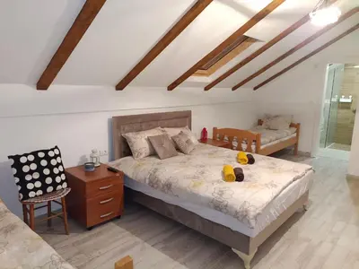 a bedroom with a large bed and a chair at Fruškogorski Đeram in Grgeteg