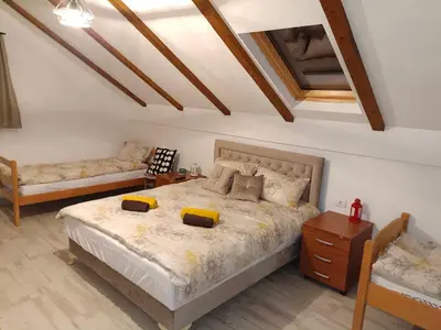 a bedroom with a large bed and a table at Fruškogorski Đeram in Grgeteg