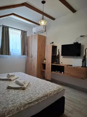 a bedroom with a bed and a tv on the wall at Fruškogorski Đeram in Grgeteg