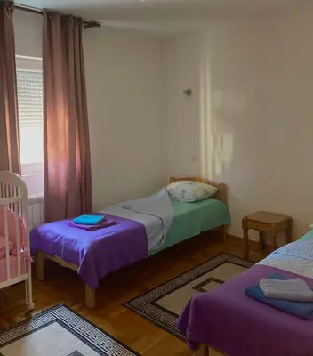 a small bedroom with two beds and a window at Amazing Memories in Belgrade