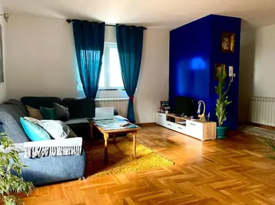 a living room with blue curtains and a couch at Amazing Memories in Belgrade