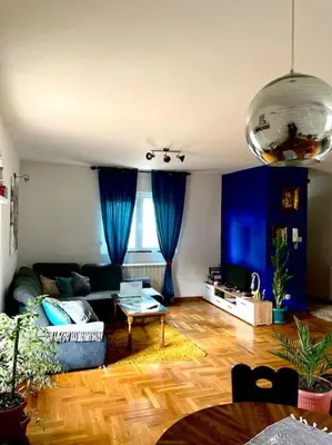 a living room with blue curtains and a couch at Amazing Memories in Belgrade