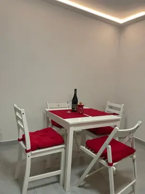 a white table with two chairs and a bottle of wine at Alexandar13 in Belgrade