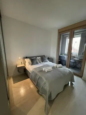 a bedroom with a bed and a large window at Iskra in Karaburma