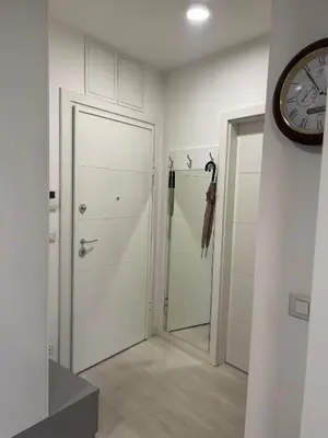 a white bathroom with a clock on the wall at Iskra in Karaburma