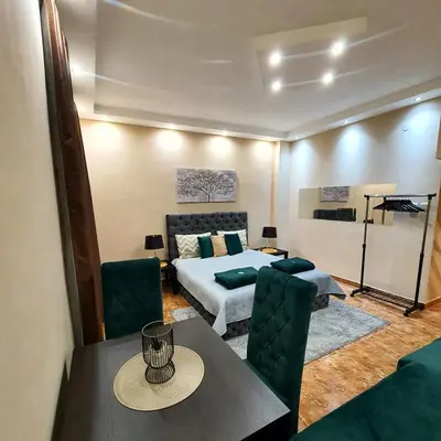 a bedroom with a bed and a table and chairs at Emerald Apartment Belgrade in Senjak (historical)