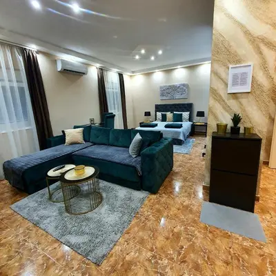 a living room with a blue couch and a table at Emerald Apartment Belgrade in Senjak (historical)