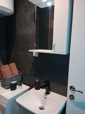a bathroom with a sink and a mirror at Apartman KLM in Pančevo