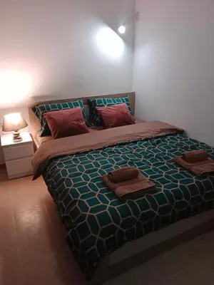 a bedroom with a large bed with two pillows on it at Apartman KLM in Pančevo