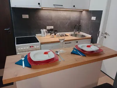 a kitchen with a counter with two plates and a sink at Apartman KLM in Pančevo