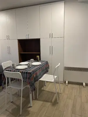 a dining room with a table and chairs and cabinets at Journey Home in Belgrade