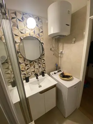 a small bathroom with a sink and a mirror at Smart lux in Tošin Bunar