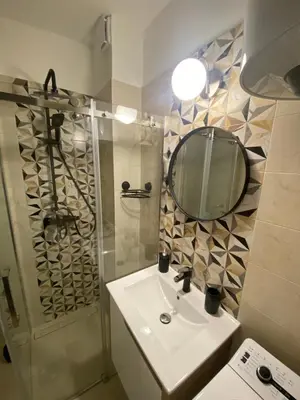 a bathroom with a sink and a mirror and a shower at Smart lux in Tošin Bunar