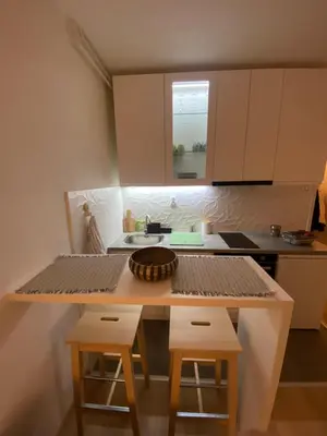 a small kitchen with a table and stools at Smart lux in Tošin Bunar
