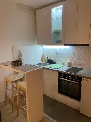 a kitchen with white cabinets and a stove top oven at Smart lux in Tošin Bunar