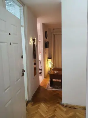 a hallway with a white door and a living room at Sunflower apartment in Žarkovo