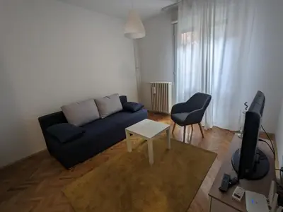 a living room with a blue couch and a table at Boba FREE PARKING in Zvezdara
