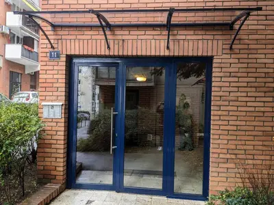 a brick building with blue doors on it at Boba FREE PARKING in Zvezdara