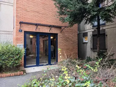 a brick building with blue doors on the side of it at Boba FREE PARKING in Zvezdara