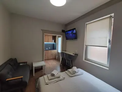 a room with a bed and a couch and a television at Centar 2 in Belgrade