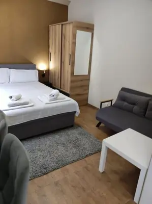 a bedroom with a bed and a couch and a table at Centar 2 in Belgrade