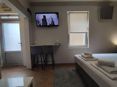a bedroom with a bed and a tv on the wall at Centar 2 in Belgrade