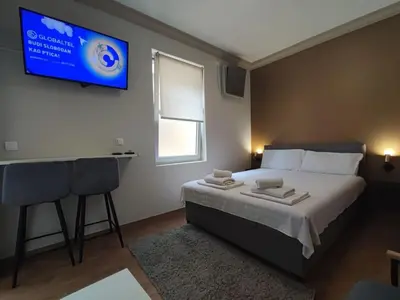 a bedroom with a bed and a tv on the wall at Centar 2 in Belgrade