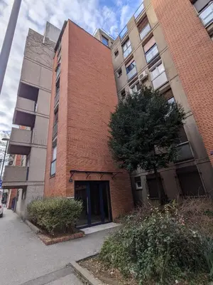 a red brick building with a door on a street at Deja FREE PARKING in Zvezdara