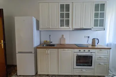 a kitchen with white cabinets and a white refrigerator at Deja FREE PARKING in Zvezdara