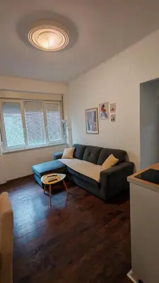 a living room with a blue couch and a table at ZELENI VENAC Studio & Apartment in Belgrade