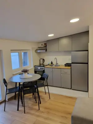 a kitchen with a table and chairs in a room at Apartment S in Belgrade
