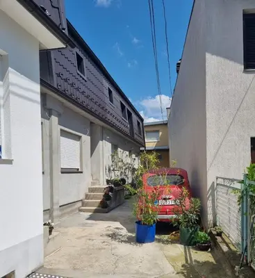 a red car parked in the driveway of a house at Apartment S in Belgrade