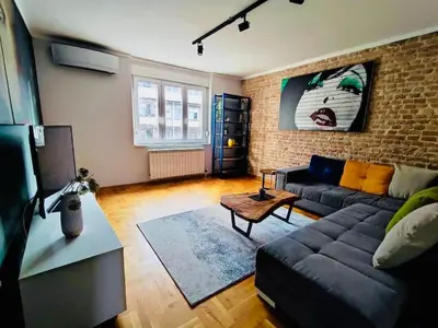 a living room with a couch and a brick wall at Vracar hideaway with private garage in Belgrade