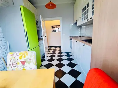 a kitchen with a black and white checkered floor at Vracar hideaway with private garage in Belgrade