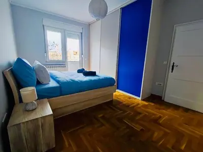 a bedroom with a blue bed and a window at Vracar hideaway with private garage in Belgrade