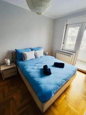 a bedroom with a blue bed with two shoes on it at Vracar hideaway with private garage in Belgrade