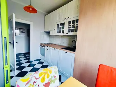a kitchen with white cabinets and a checkered floor at Vracar hideaway with private garage in Belgrade